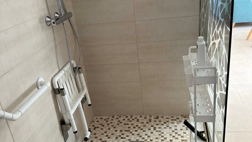 douche italienne avec barre d'appui et chaise amovible pour PMR en fauteuil roulant